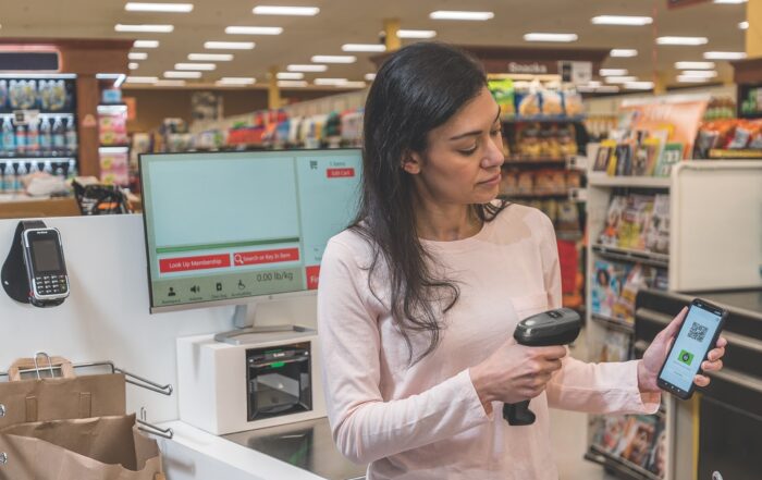 A woman uses Zebra scanner to scan a QR-code from a smartphone.